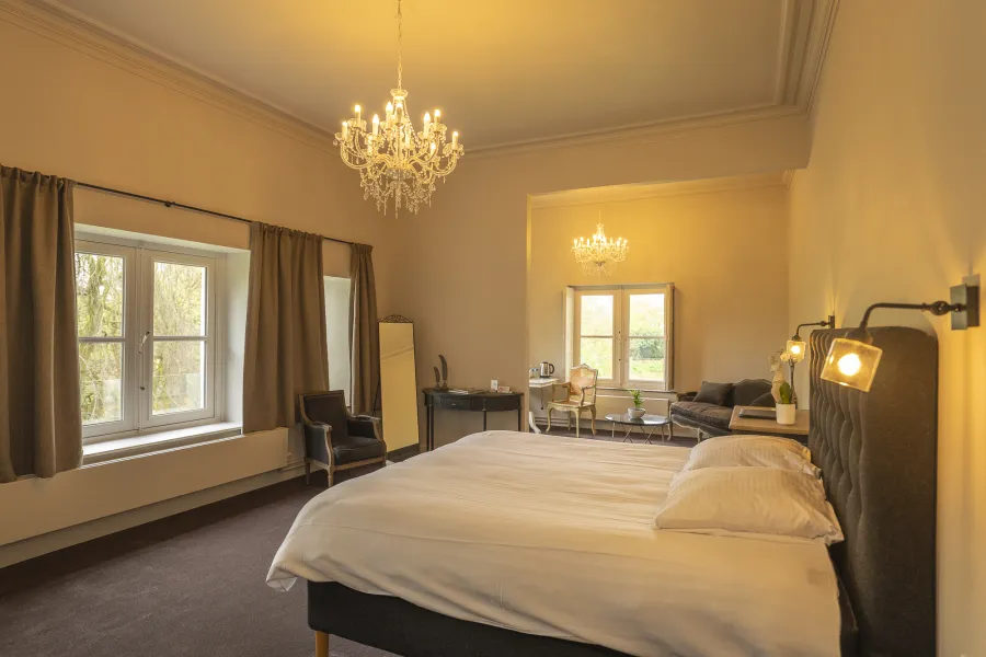 Spacious Classic Suite with bed, sitting area and chandelier