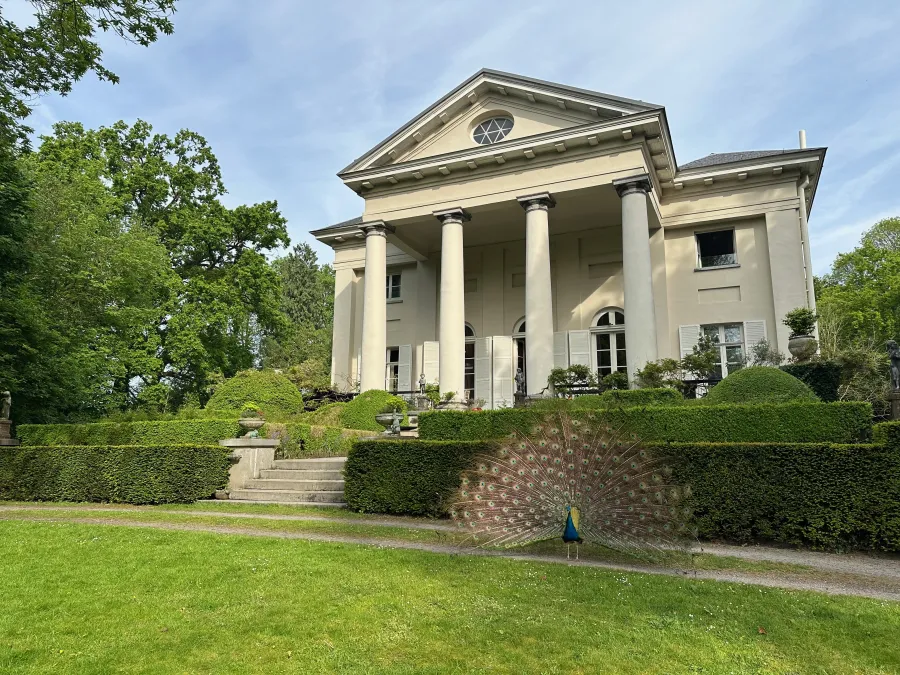 Leyselebeke Castle, its landscaped garden and a peacock
